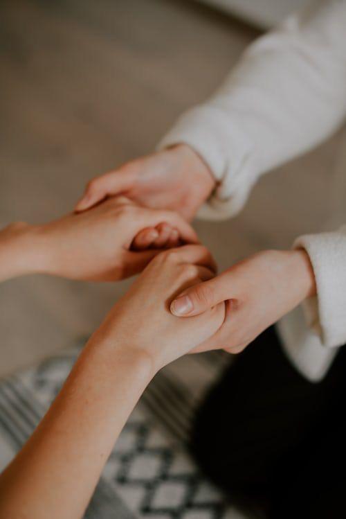 Dos personas tomándose de las manos en un gesto de acompañamiento terapéutico